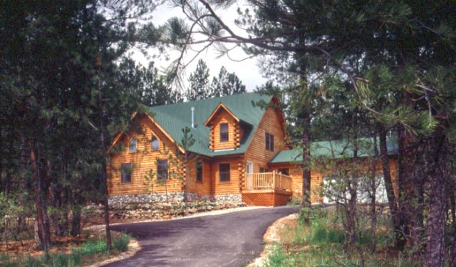 log home with green asphalt shingle roof